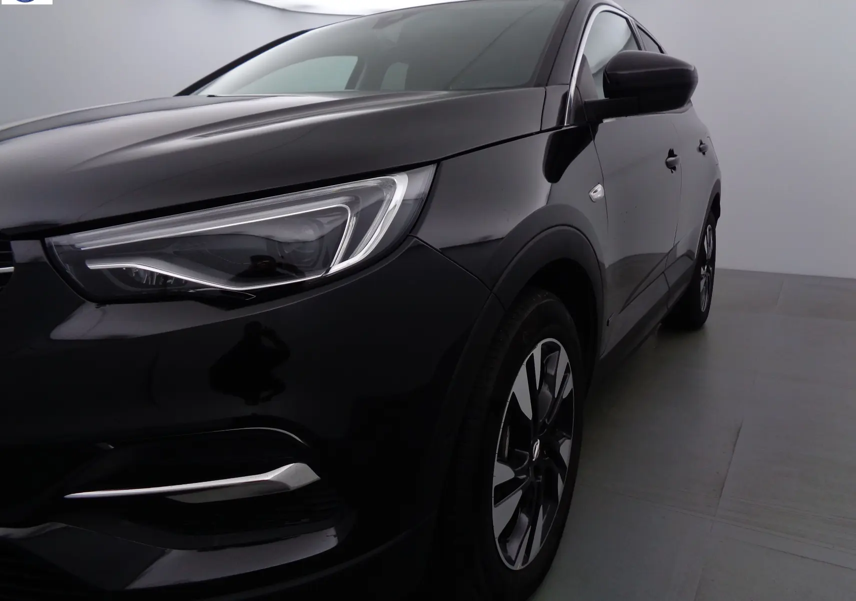 Vue 3/4 avant droit d'un Opel Grandland X noir métal avec phares LED et jantes alliage distinctives.