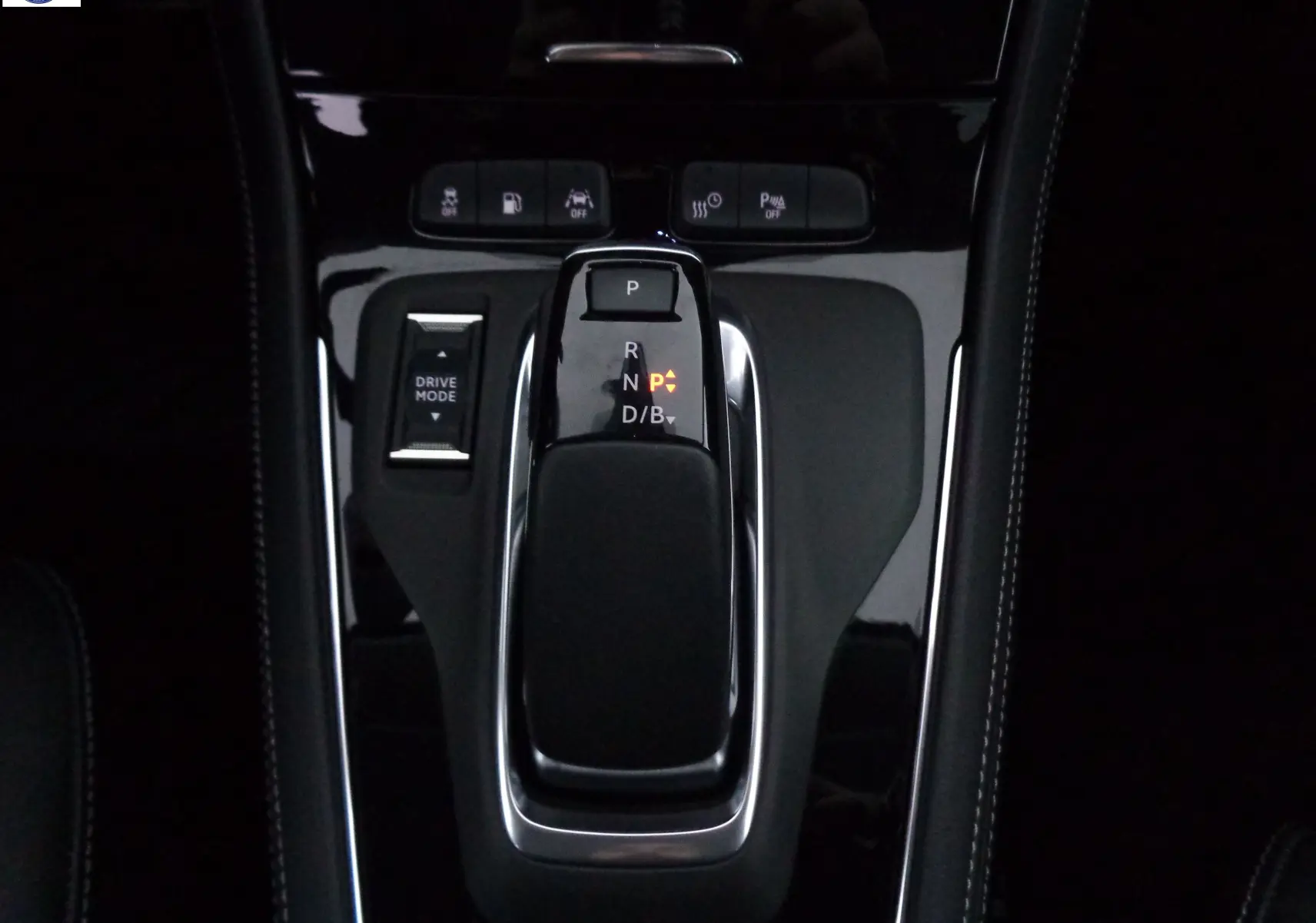 Le levier de vitesses automatique noir brillant de l'Opel Grandland X hybride, avec boutons de contrôle et mode de conduite visible.