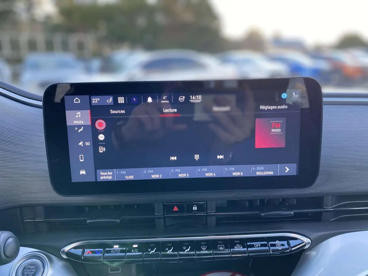 Écran tactile central affichant la radio FM dans l'habitacle moderne de la FIAT 500 électrique noire.