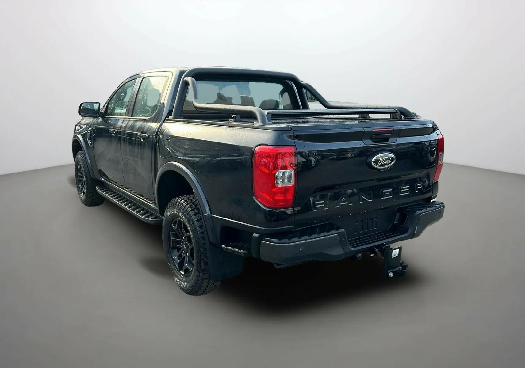 Ford Ranger 2025 noir shadow vu en 3/4 arrière droit avec barre de protection et attelage visible.