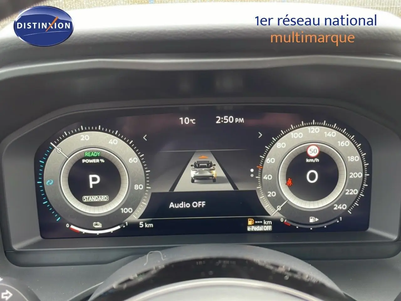 Vue rapprochée du tableau de bord numérique du Nissan Qashqai gris, affichant la vitesse et l'état du véhicule.