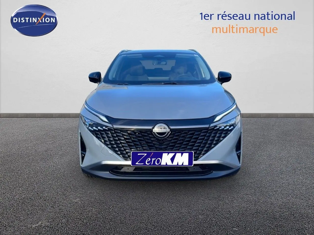 Vue frontale du Nissan Qashqai 1.5 E-POWER 205CH N-CONNECTA gris argile métal avec calandre noire distinctive.