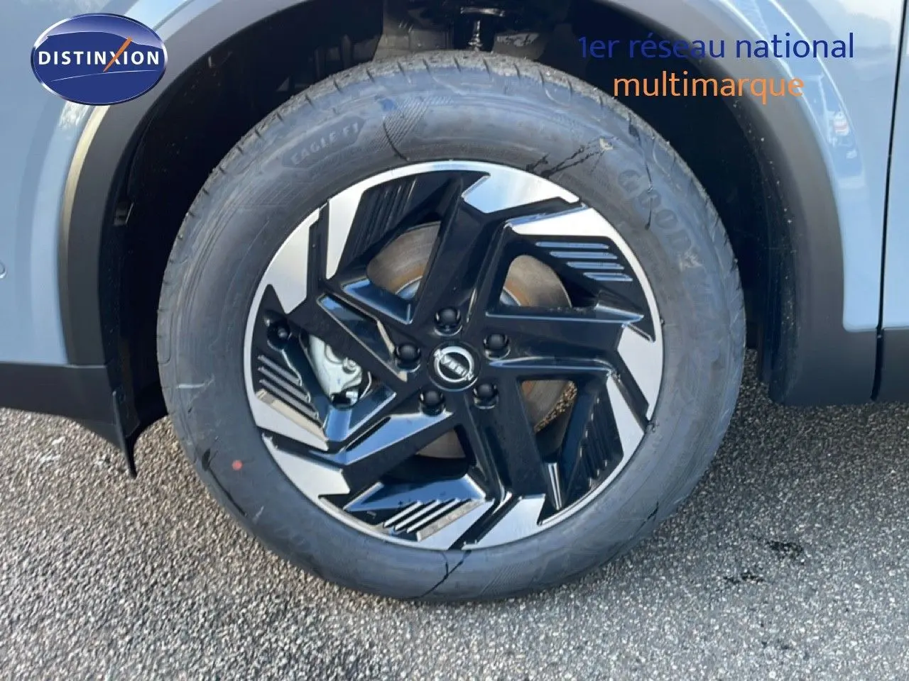 Gros plan sur la roue avant gauche du Nissan Qashqai 2025 gris argile métal, mettant en valeur la jante noire et argentée au design moderne.