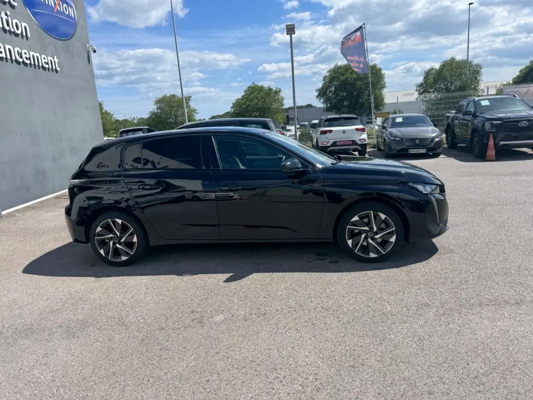 Peugeot 308 Hybrid noir vue de profil côté gauche, avec jantes alliage 17 pouces et vitres teintées.