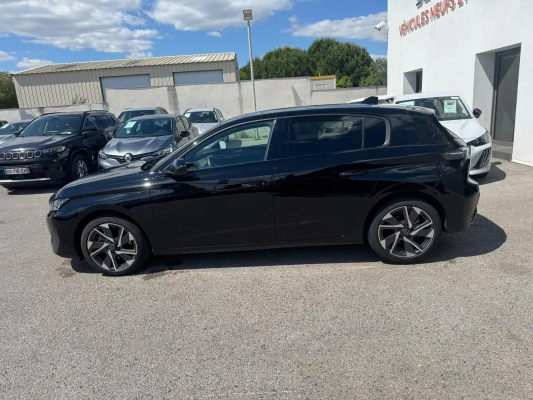 Peugeot 308 Hybrid noir vue de profil côté gauche, avec jantes alliage 17 pouces et toit noir brillant.