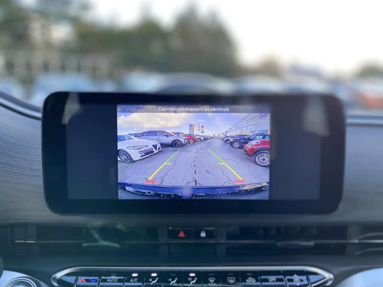 Écran de caméra de recul affichant un parking, vu depuis l’intérieur d’une FIAT 500 électrique noire.