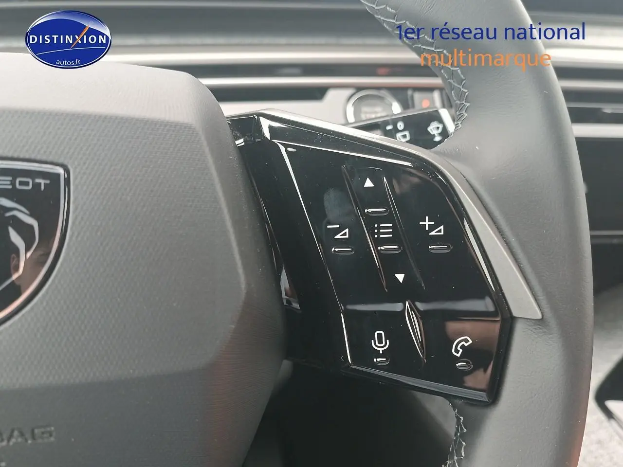 Gros plan sur les commandes vocales et audio au volant cuir du Peugeot 5008 Hybrid 145 allure gris Artense.