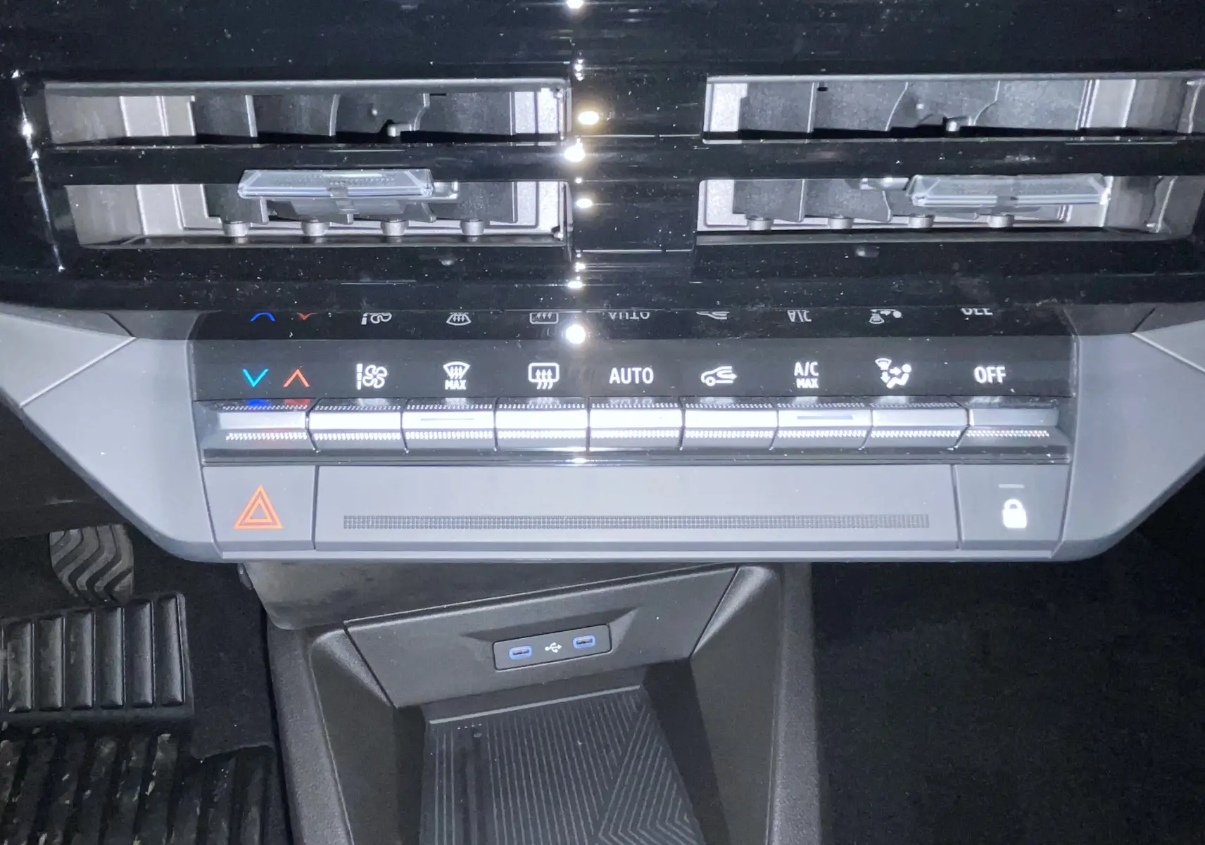 Vue rapprochée de la console centrale de la Renault Clio VI TCE 115ch Techno, montrant les commandes de climatisation et ports USB.