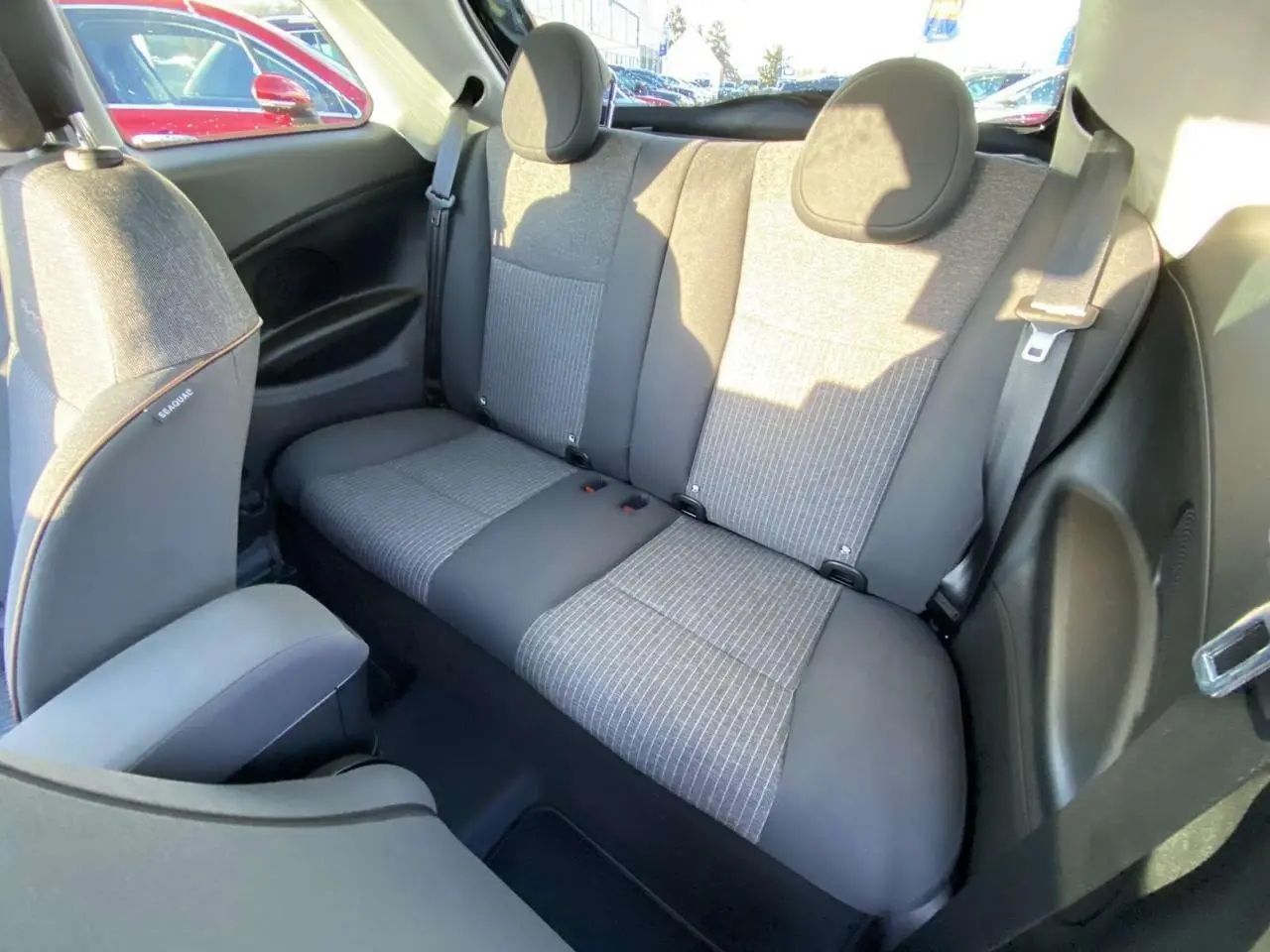 Vue intérieure arrière de la banquette arrière grise et noire de la Fiat 500 électrique 2022 avec ceinture de sécurité.