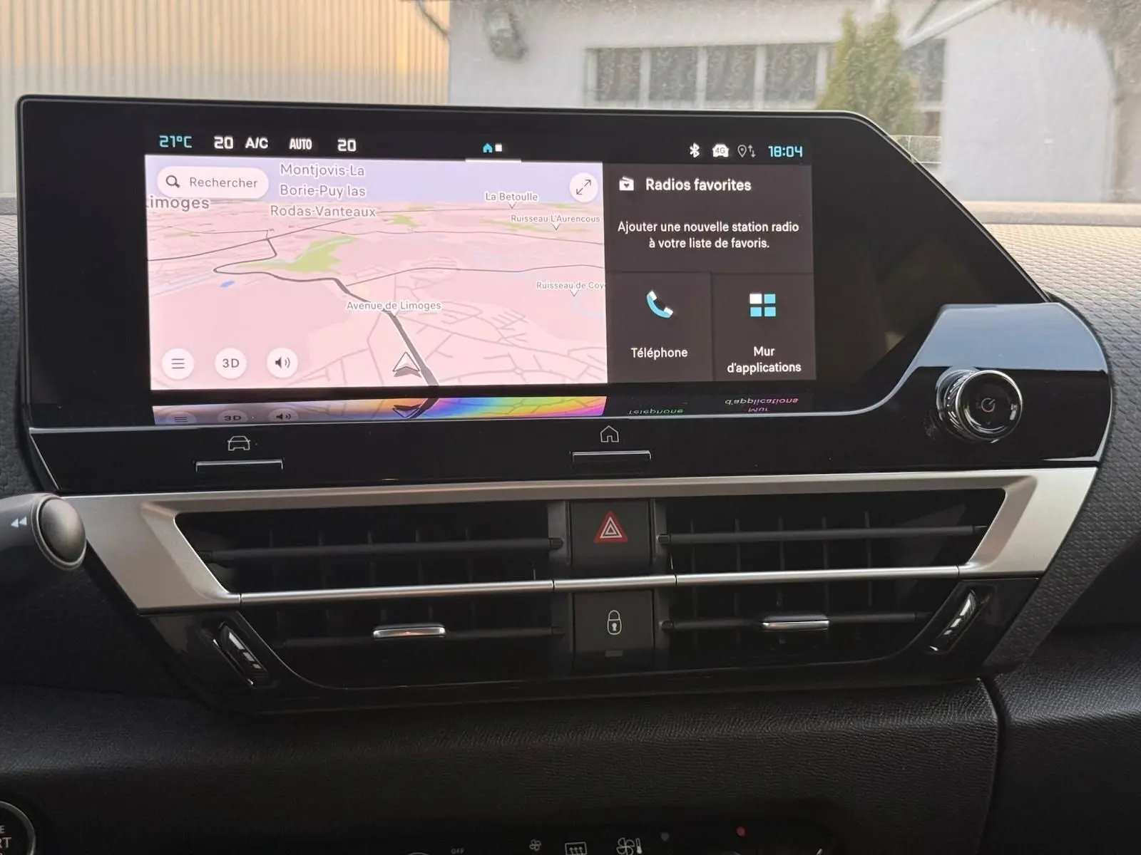 Vue rapprochée du tableau de bord du Citroën C4 hybride 2025 avec écran tactile et commandes de climatisation.