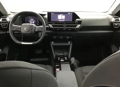 Vue intérieure avant du Citroën C4 hybride 2025, tableau de bord moderne avec écran tactile affichant la caméra de recul.