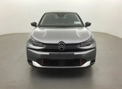 Vue 3/4 avant droit du Citroën C4 hybride gris Mercury, mettant en valeur la calandre moderne et les jantes noires distinctives.