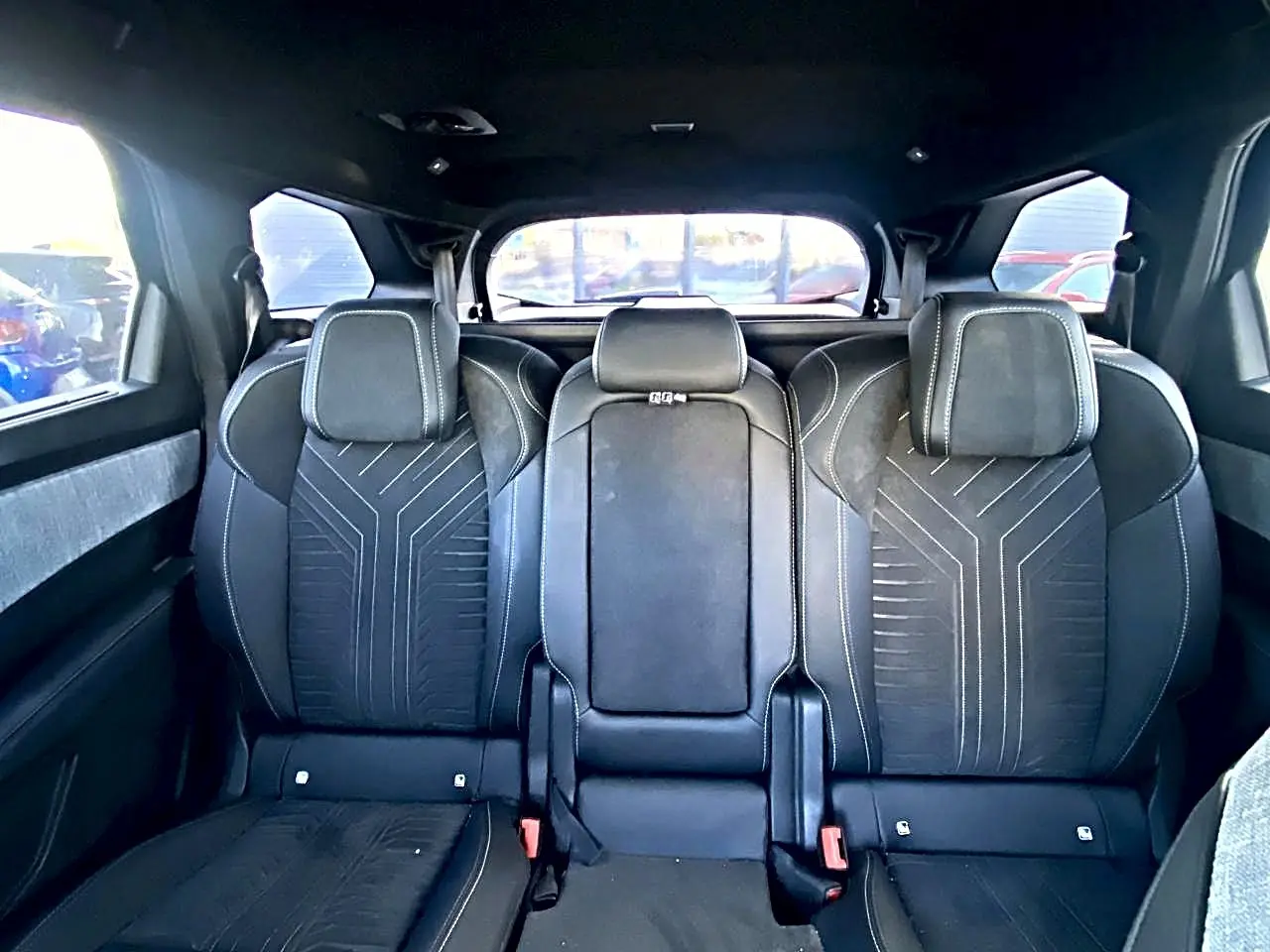 Vue arrière intérieure des sièges noirs du Peugeot 5008 Hybrid 145 GT avec appuis-tête et coutures contrastées.