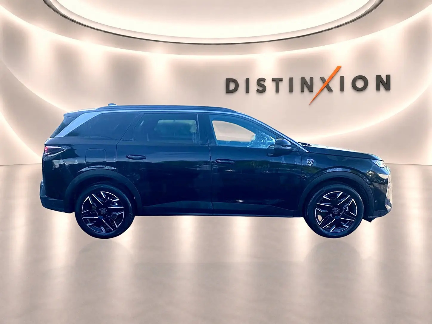 Profil droit du Peugeot 5008 noir 2025 avec jantes alliage et badge GT sur l'aile avant, en studio lumineux.