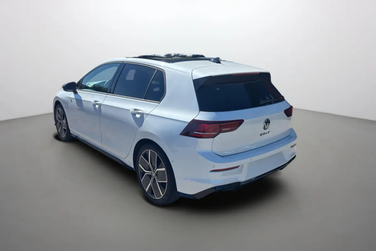 Vue 3/4 arrière droite d'une Volkswagen Golf blanche oryx avec toit ouvrant panoramique et vitres surteintées.