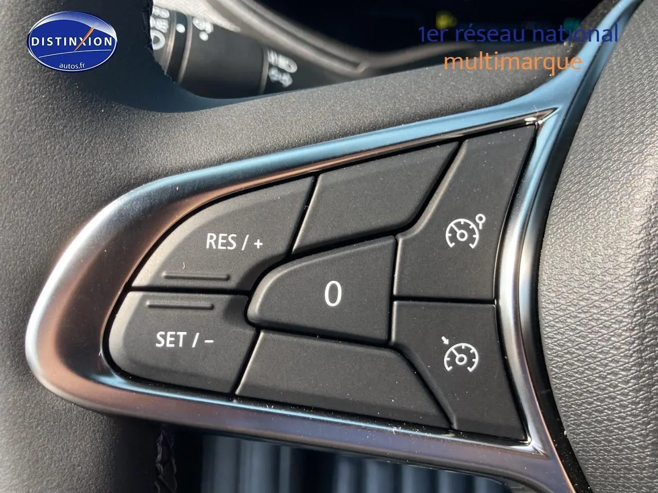 Gros plan sur les commandes de régulateur de vitesse au volant d'une Renault Clio V noire Étoile.