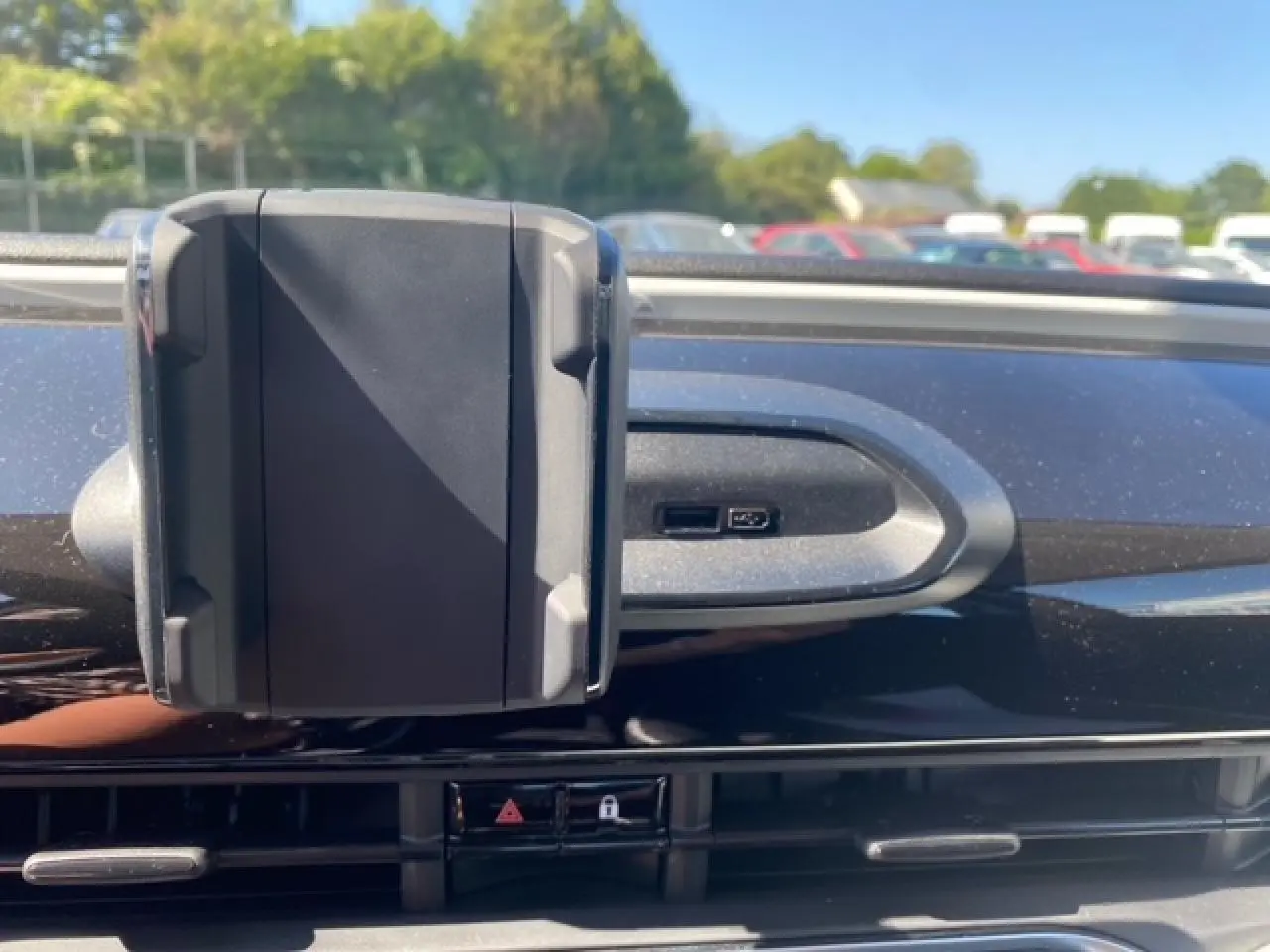 Support smartphone fixé sur la planche de bord noire de la Fiat 500 électrique blanche, vue rapprochée côté passager.