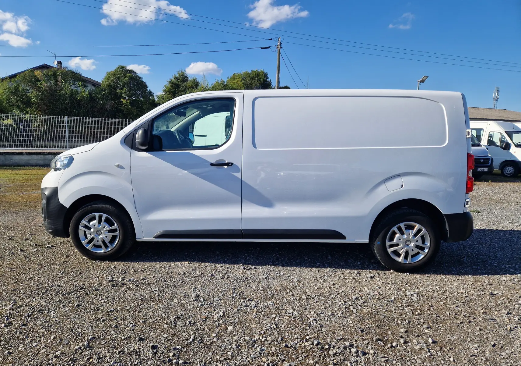 Profil côté gauche d'un Peugeot Expert Fourgon blanc 2020, avec porte latérale coulissante et jantes alliage visibles.