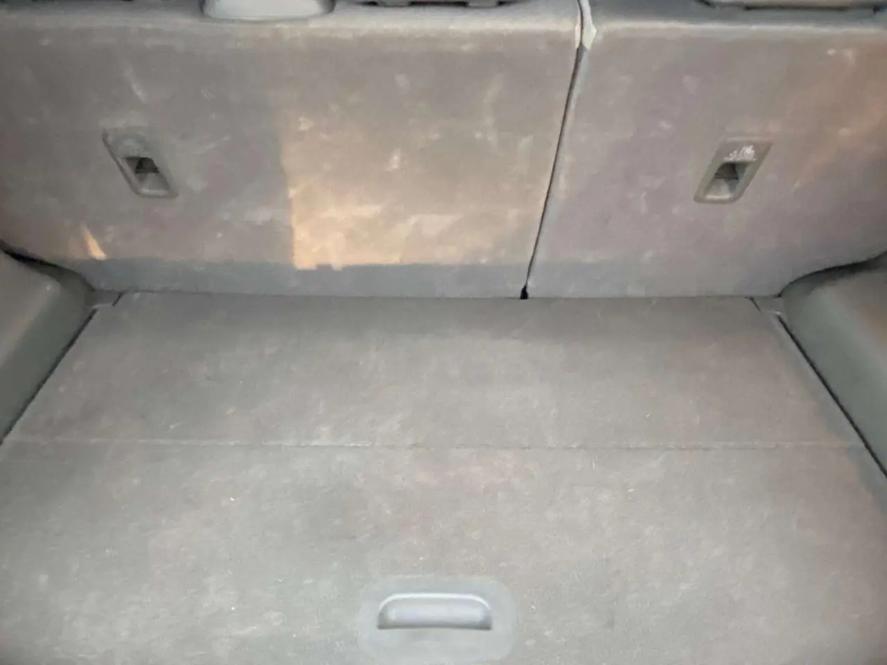 Coffre spacieux du Kia Soul électrique 2016, vue intérieure arrière avec banquette rabattue et revêtement gris.