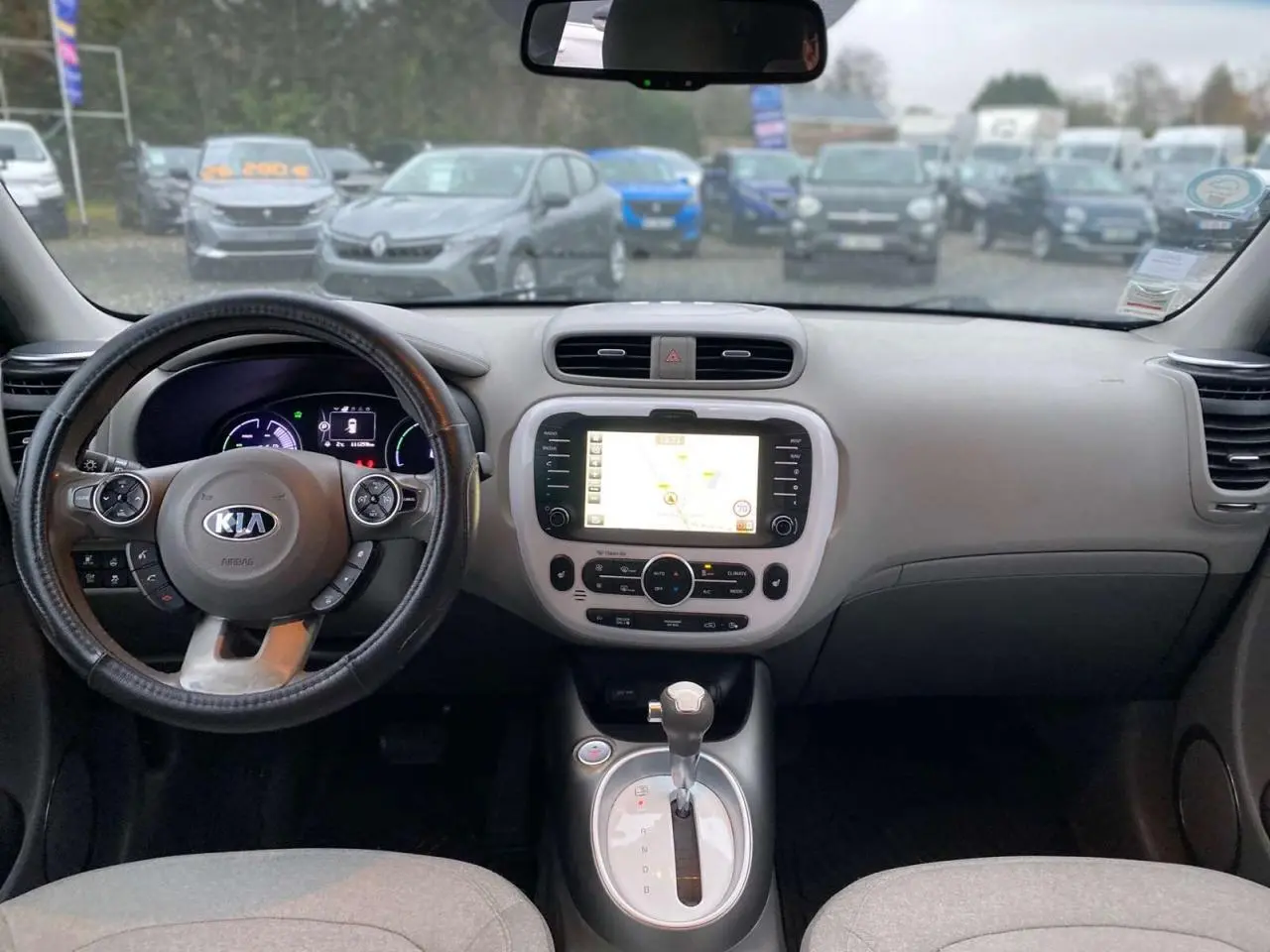 Intérieur du Kia Soul électrique 2016 vu de face, tableau de bord avec écran tactile et volant multifonction noir.