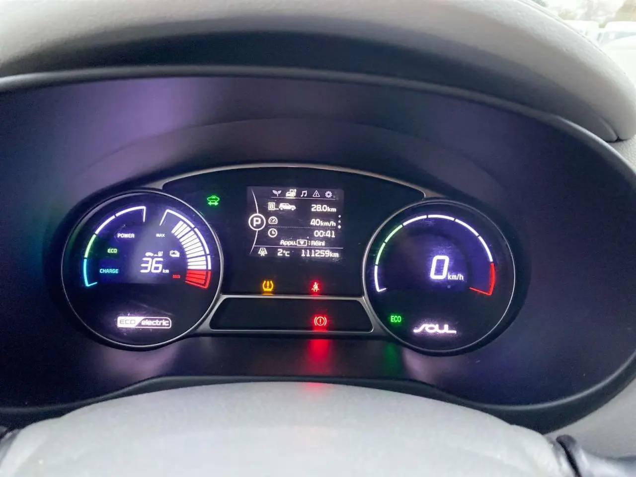 Vue intérieure du volant et du tableau de bord du KIA Soul électrique noir, avec commandes au volant visibles.