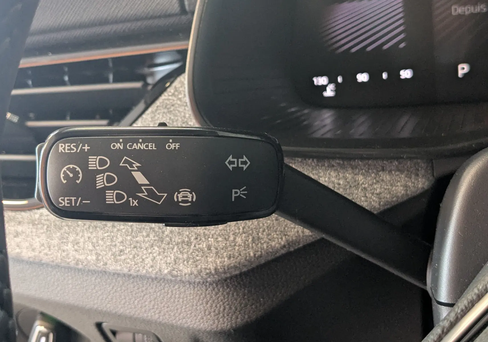 Gros plan sur la manette de commande noire à gauche du volant dans l'habitacle du Skoda Kamiq gris graphite.