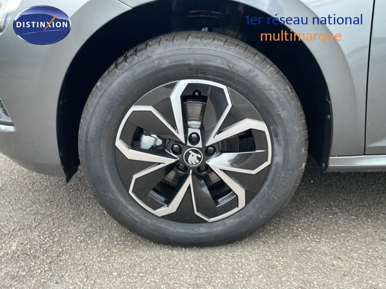 Gros plan sur la roue avant gauche du Skoda Kamiq gris graphite métal, mettant en valeur la jante alliage noire et argentée.