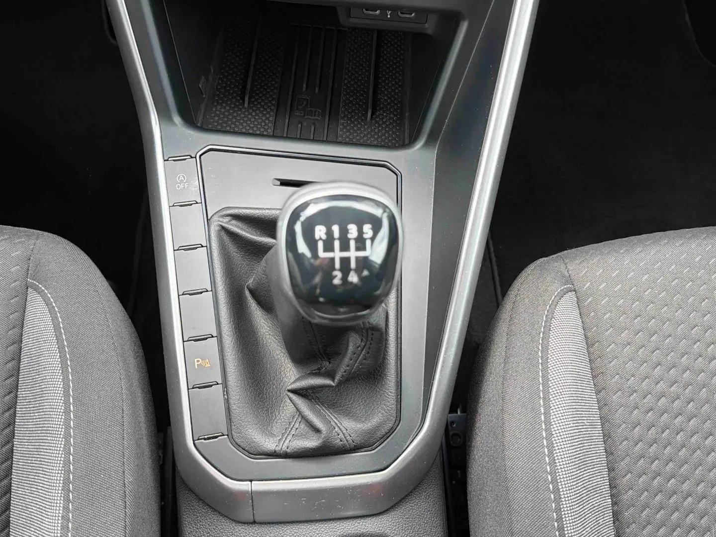 Vue rapprochée de la boîte manuelle 5 vitesses et des sièges gris de la Volkswagen Polo 2025.