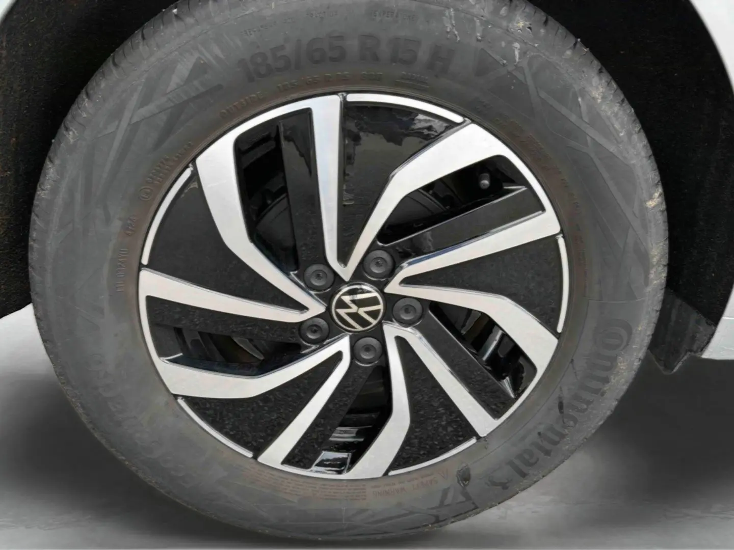 Gros plan sur la jante alliage 15 pouces noire et argentée de la Volkswagen Polo grise, avec pneu Continental visible.