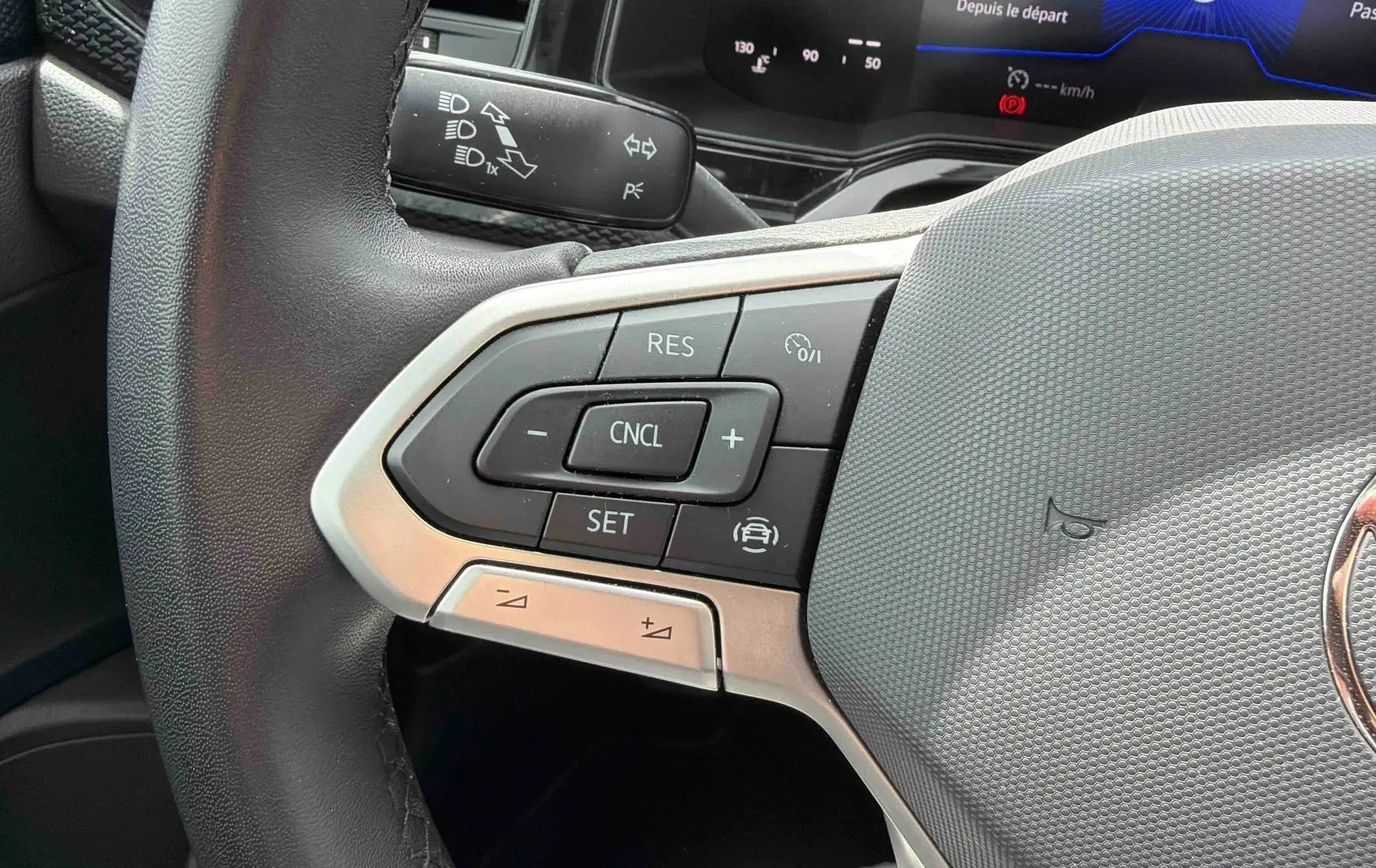 Gros plan sur le volant multifonctions gris d’une Volkswagen Polo 2025 avec commandes de régulateur de vitesse.
