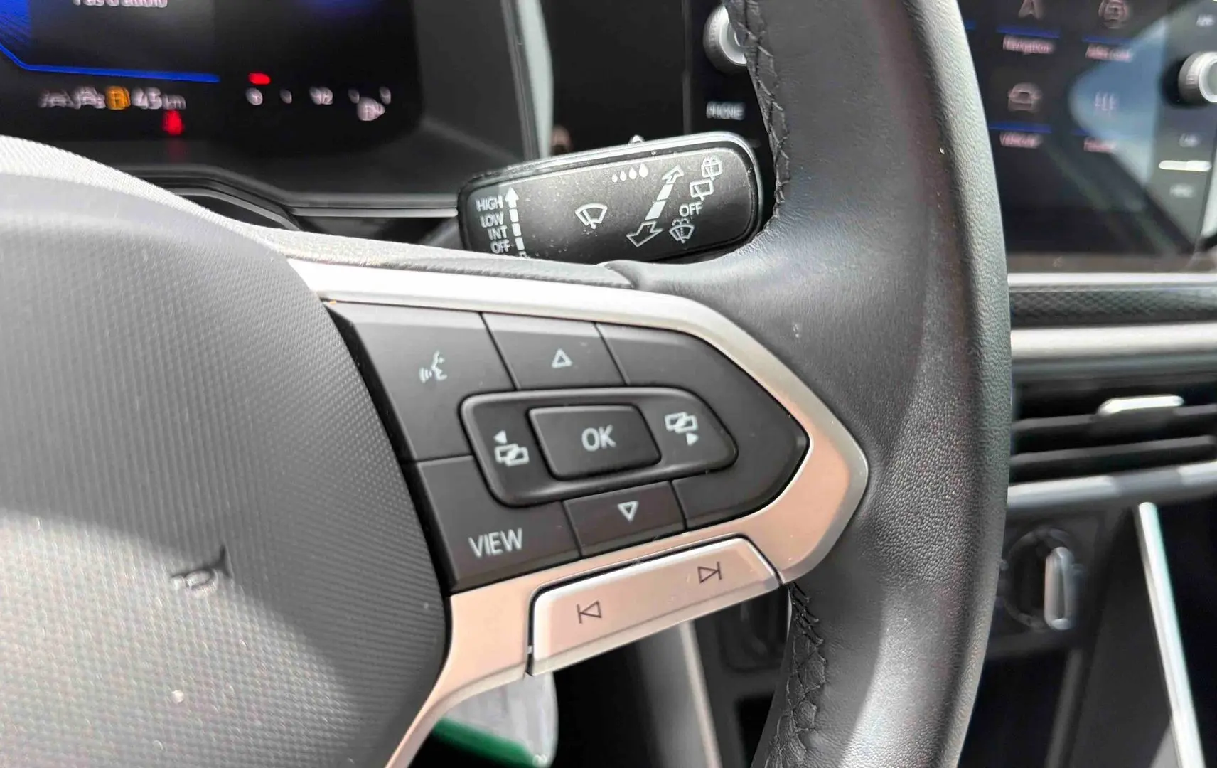 Gros plan sur le volant noir de la Volkswagen Polo 2025, côté gauche avec commandes multifonctions visibles.
