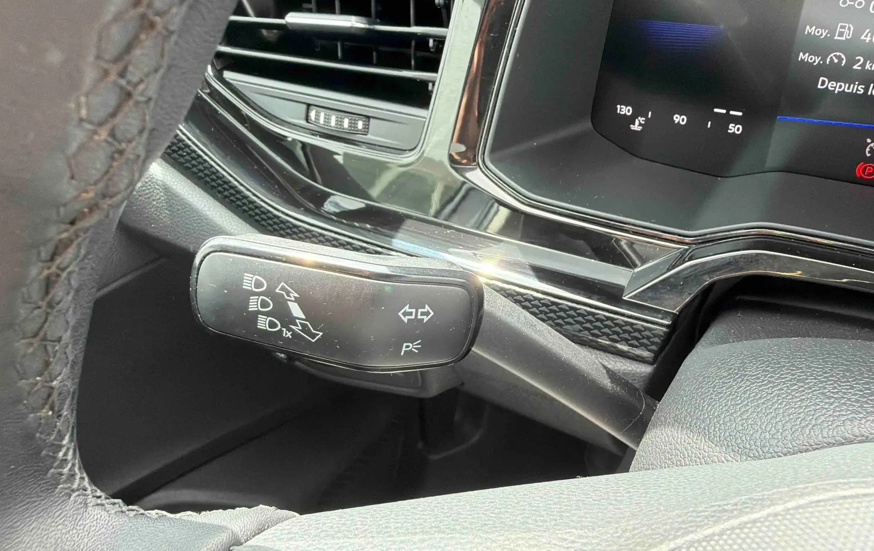 Détail du commodo gauche noir avec commandes d’éclairage sur le tableau de bord digital d’une Volkswagen Polo 2025.