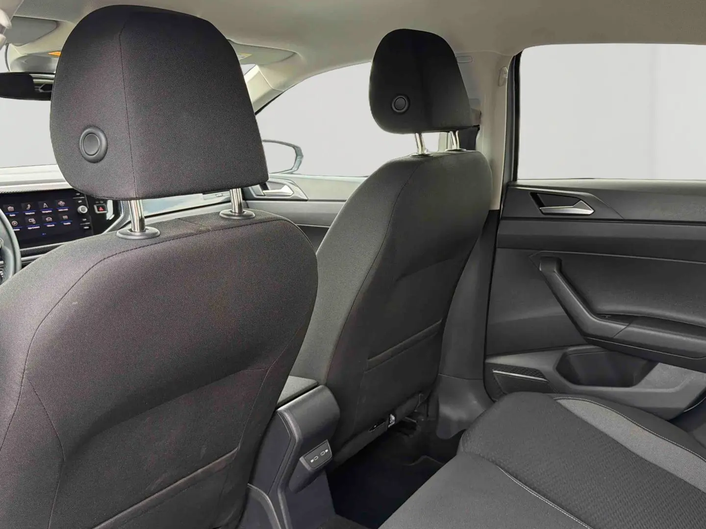 Vue intérieure arrière de la Volkswagen Polo 2025 gris, montrant les sièges avant et la console centrale avec ports USB-C.