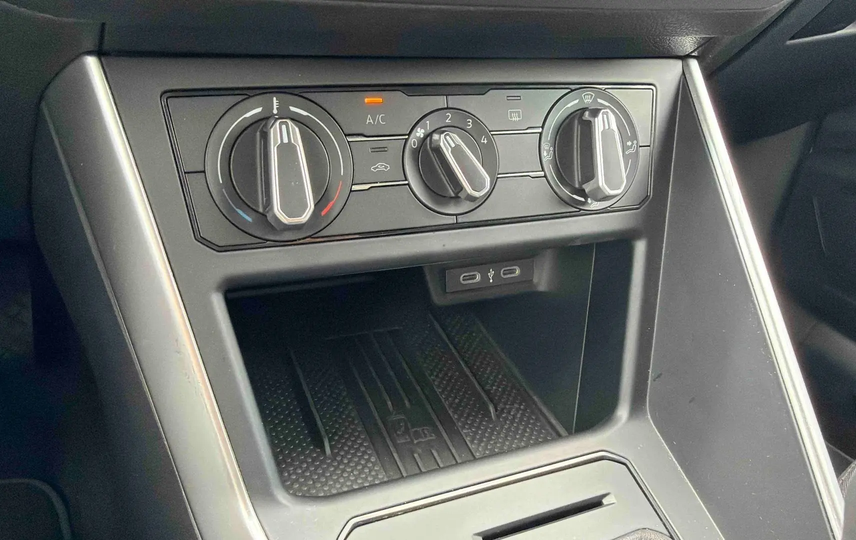 Console centrale vue de face avec commandes manuelles de climatisation et ports USB-C dans une Volkswagen Polo grise 2025.