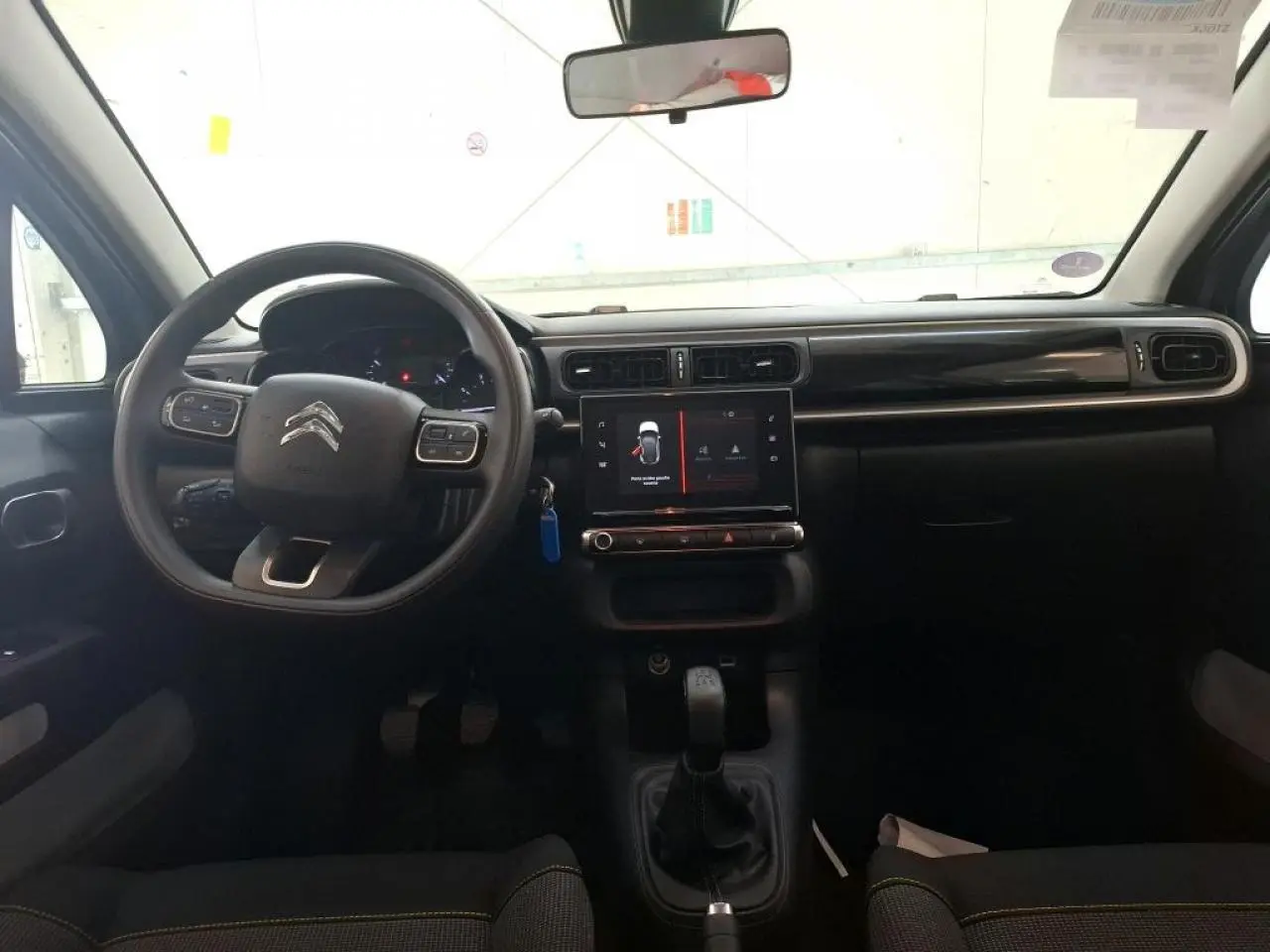Intérieur de la Citroën C3 2024 gris foncé, vue de face sur le tableau de bord avec écran tactile et volant multifonction.