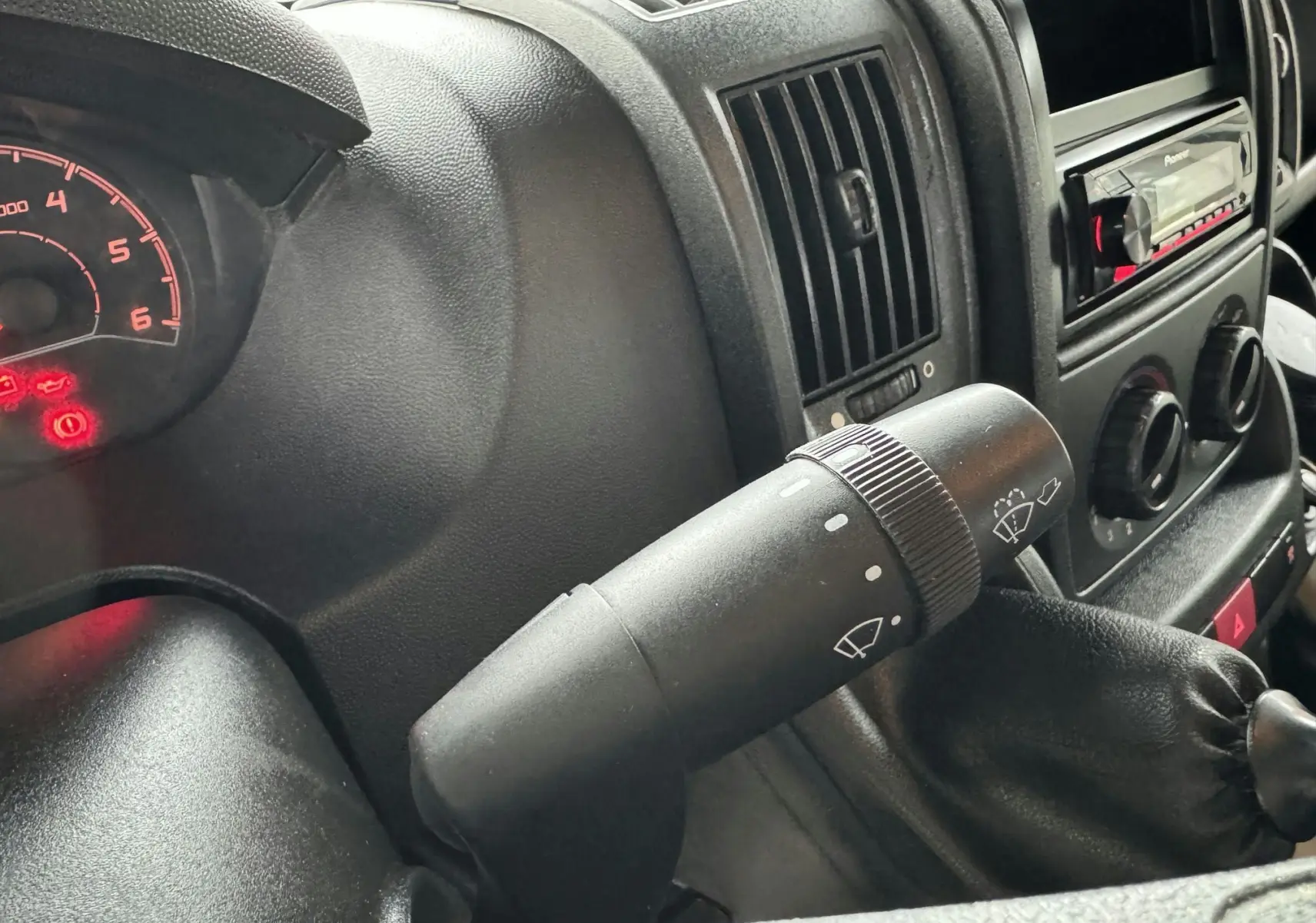 Gros plan sur la commande d'essuie-glace du tableau de bord noir du Citroën Jumper benne rouge 2019.