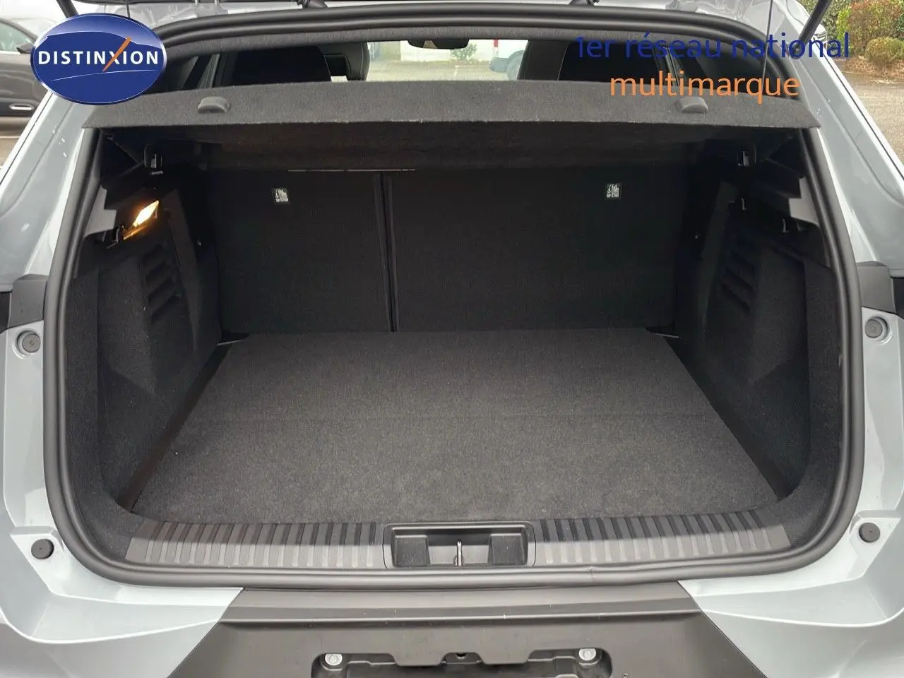 Coffre ouvert vu de l'arrière du Renault Symbioz gris Rafale Métal, montrant un espace de chargement vide et propre.