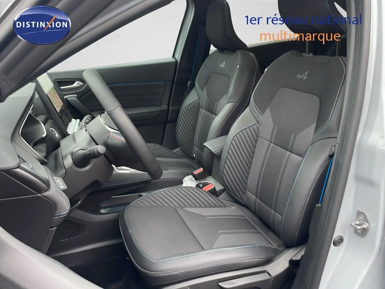 Vue intérieure côté conducteur de la Renault Symbioz E-Tech Full Hybrid 2025, sièges noirs avec surpiqûres bleues et logo Alpine.