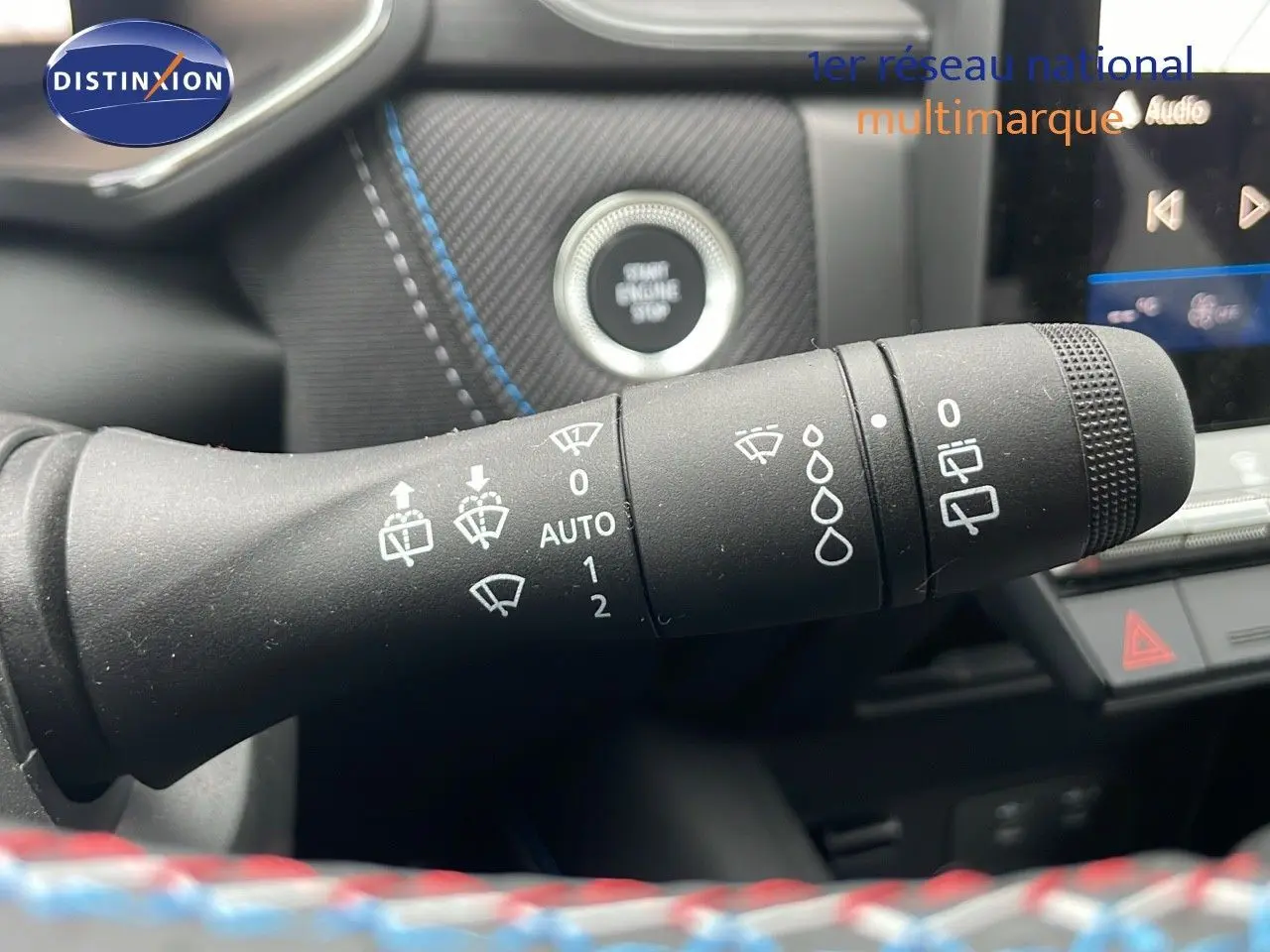 Gros plan sur la commande des essuie-glaces dans l’habitacle du Renault Symbioz gris Rafale Métal, avec bouton start visible.