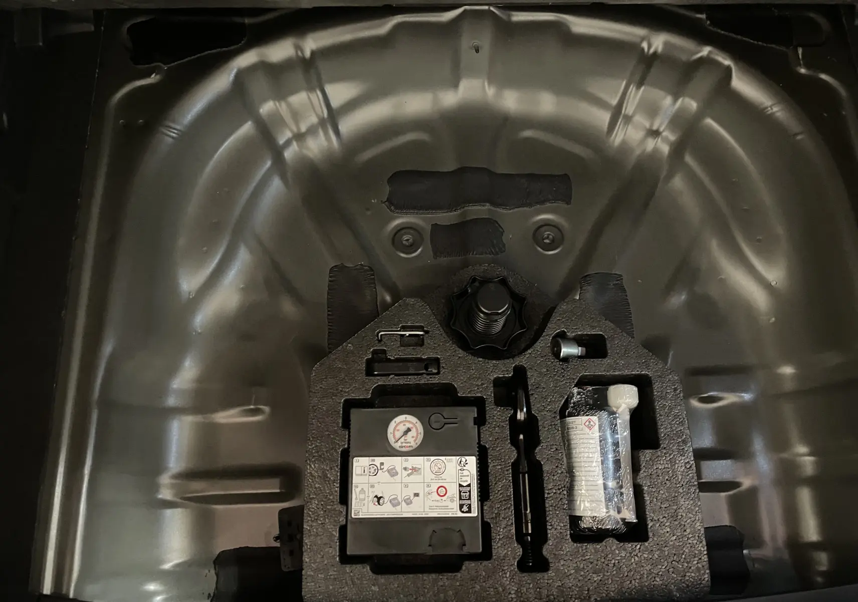 Gros plan sur le compartiment de roue de secours du CUPRA Formentor 2023 avec kit de réparation et outils intégrés.