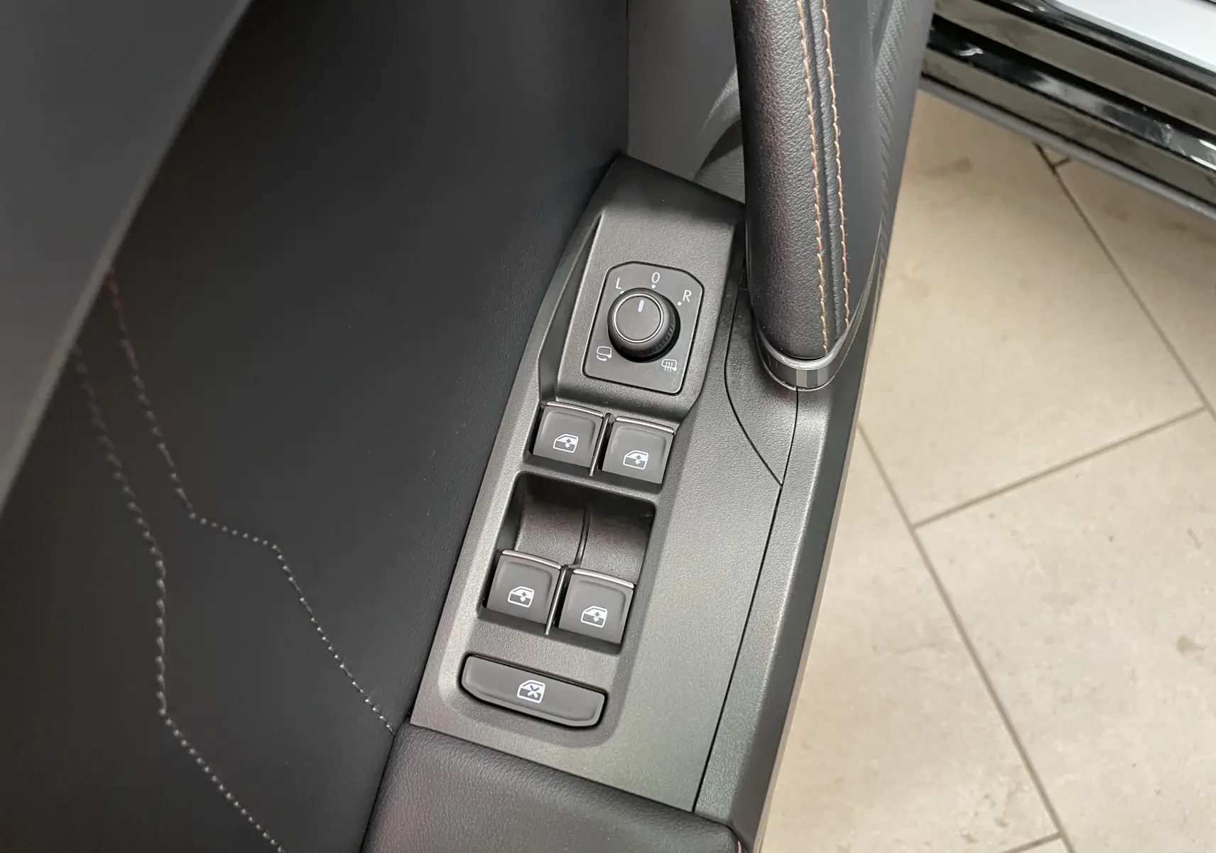 Gros plan sur les commandes des vitres et rétroviseurs côté gauche d'une CUPRA Formentor Noir Minuit 2023.