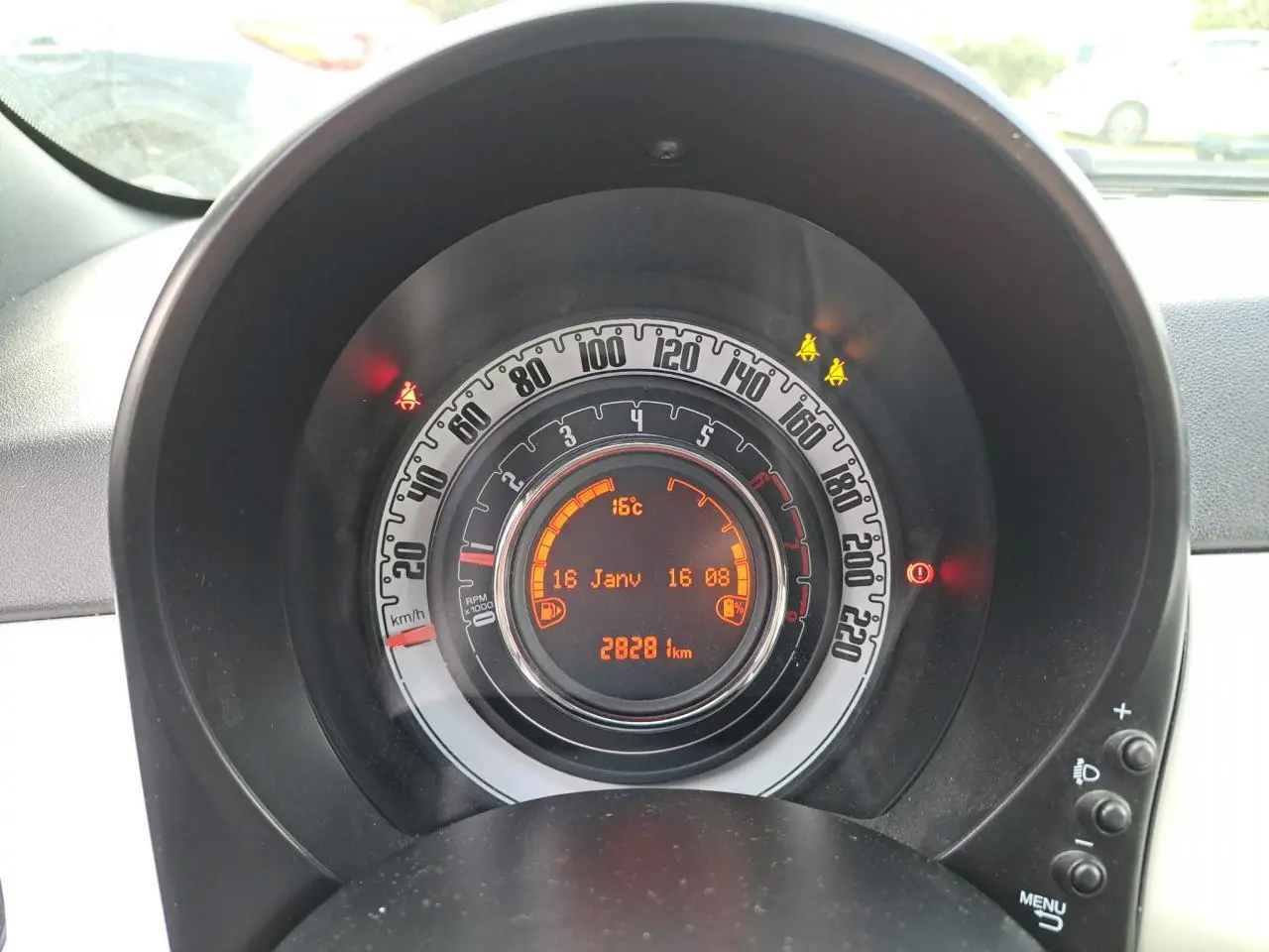 Gros plan sur le tableau de bord circulaire de la Fiat 500 Cabriolet blanche, affichant vitesse, température et kilométrage.