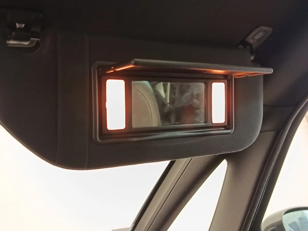 Miroir de courtoisie éclairé sur pare-soleil intérieur côté conducteur d'une DS5 noire, vue rapprochée.