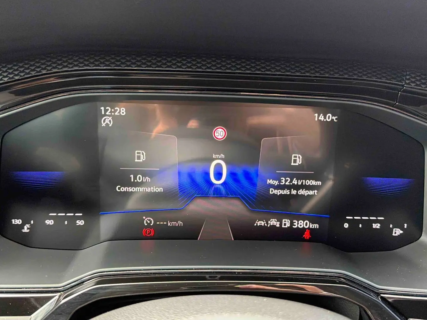 Vue rapprochée du combiné d'instruments digital de la Volkswagen Polo grise, affichant vitesse et consommation.
