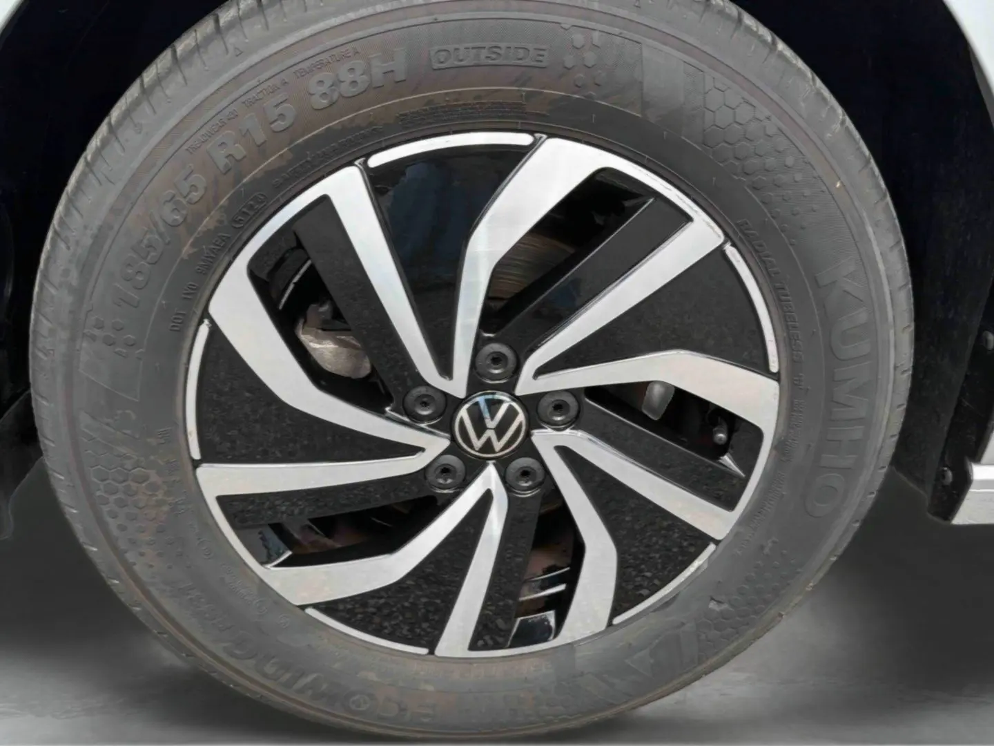 Gros plan sur la jante en alliage noir et argent de la Volkswagen Polo grise, mettant en valeur le logo VW central.
