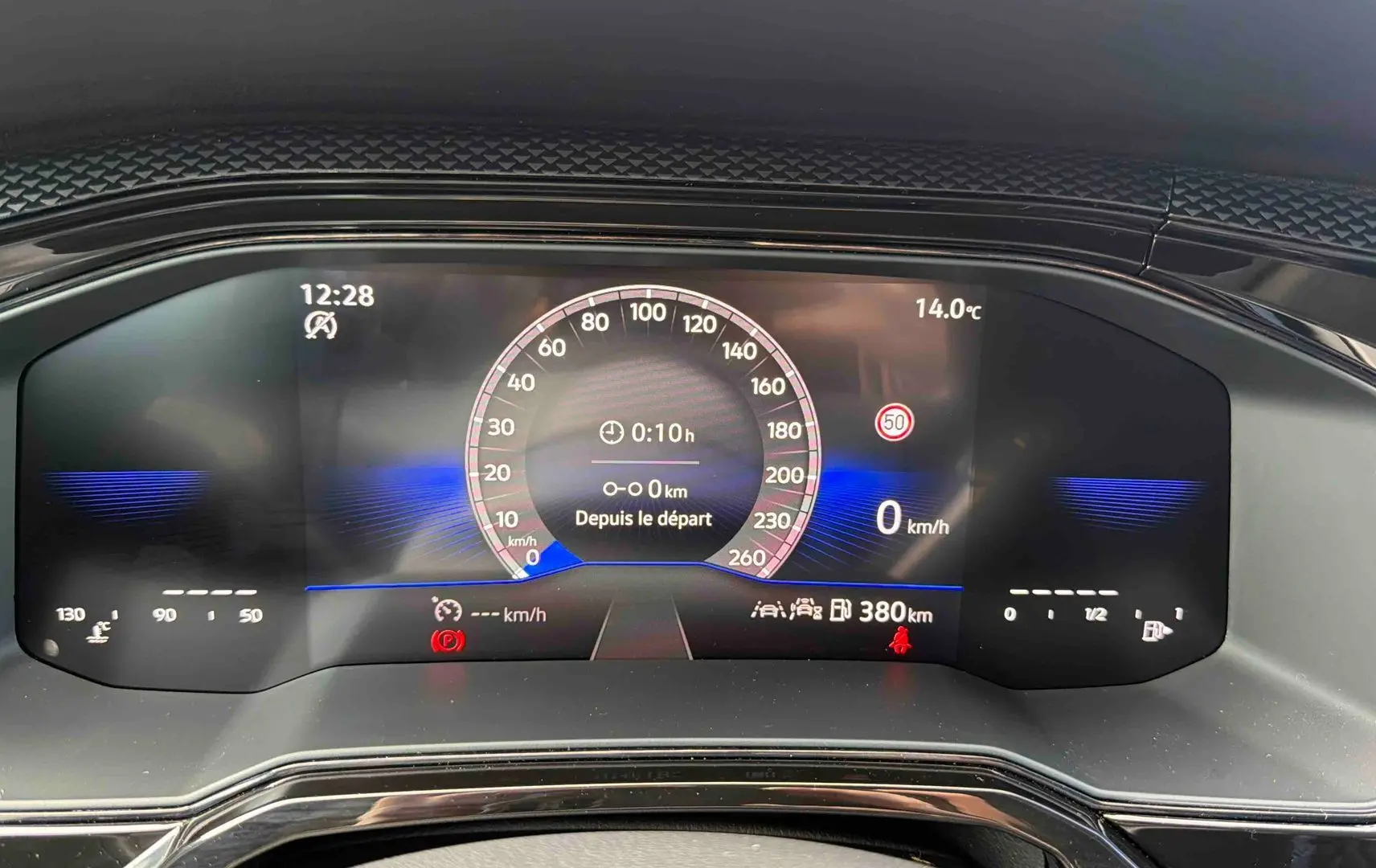 Gros plan sur le combiné d'instruments digital de la Volkswagen Polo grise, affichant la vitesse et la température extérieure.