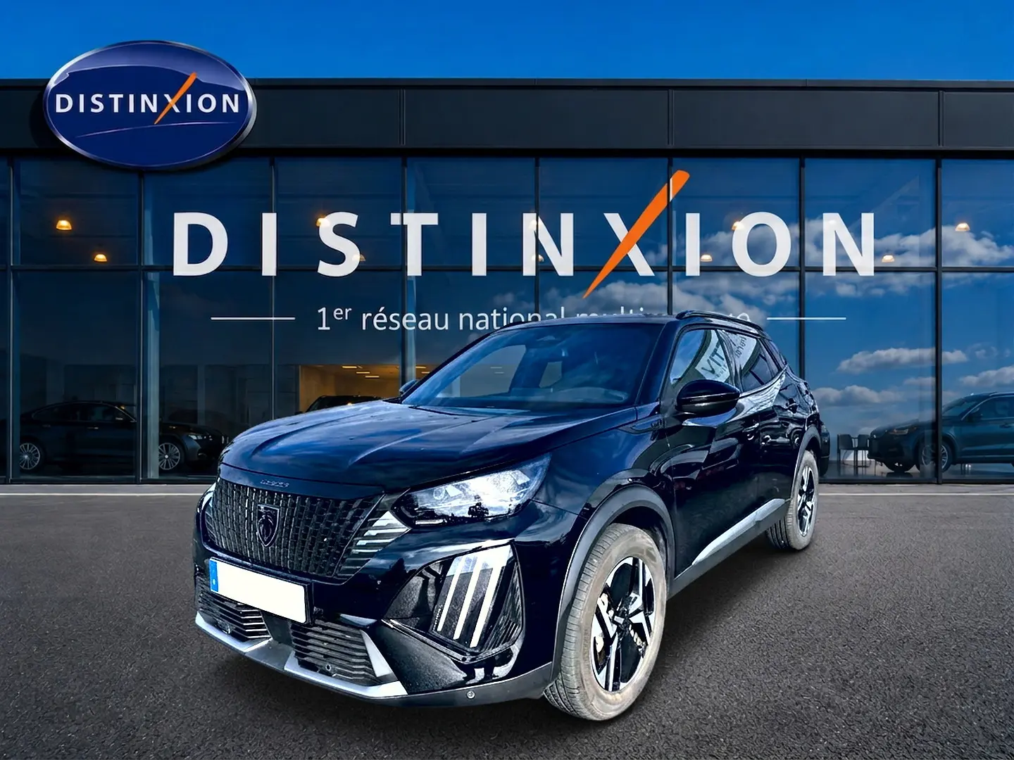 Peugeot 2008 noir en 3/4 avant droit, avec calandre distinctive et jantes alu bicolores devant showroom Distinxion.