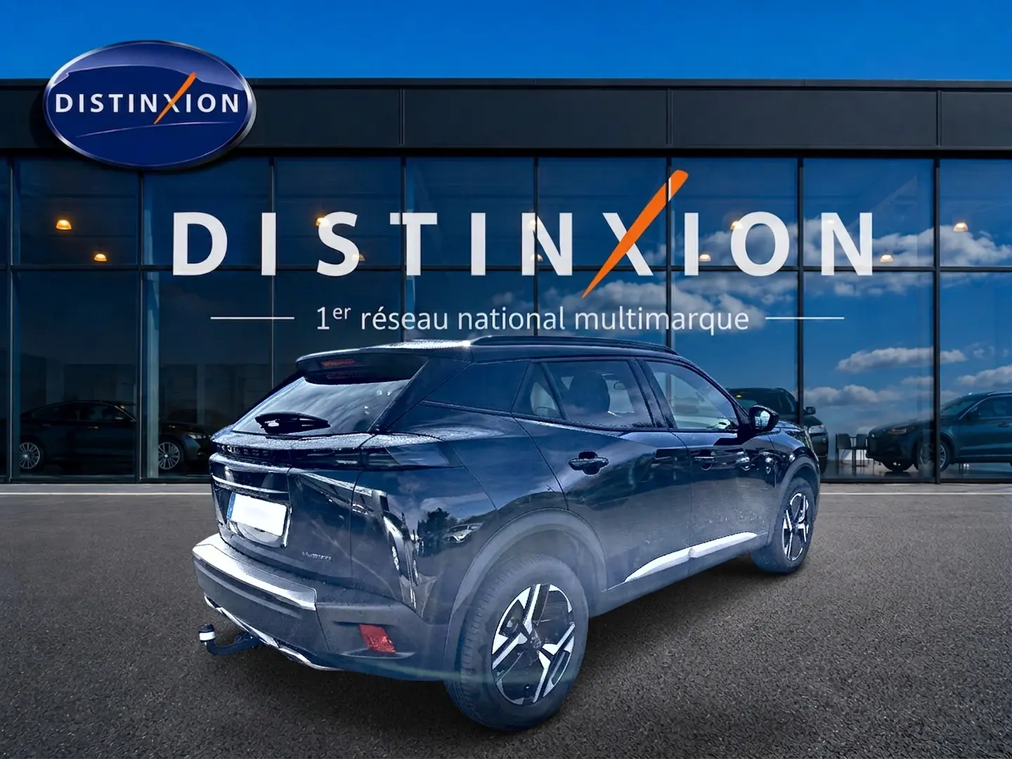 Peugeot 2008 noir vue 3/4 arrière droit, avec jantes alu et attelage, devant vitrine Distinxion.