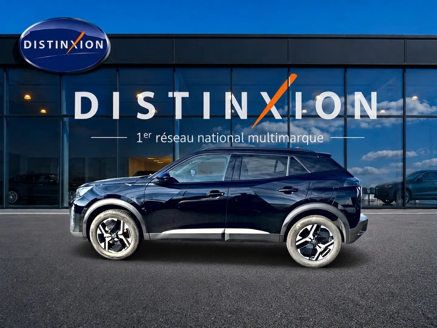 Profil côté gauche d'un Peugeot 2008 noir 2025 garé devant une vitrine avec logo Distinxion.