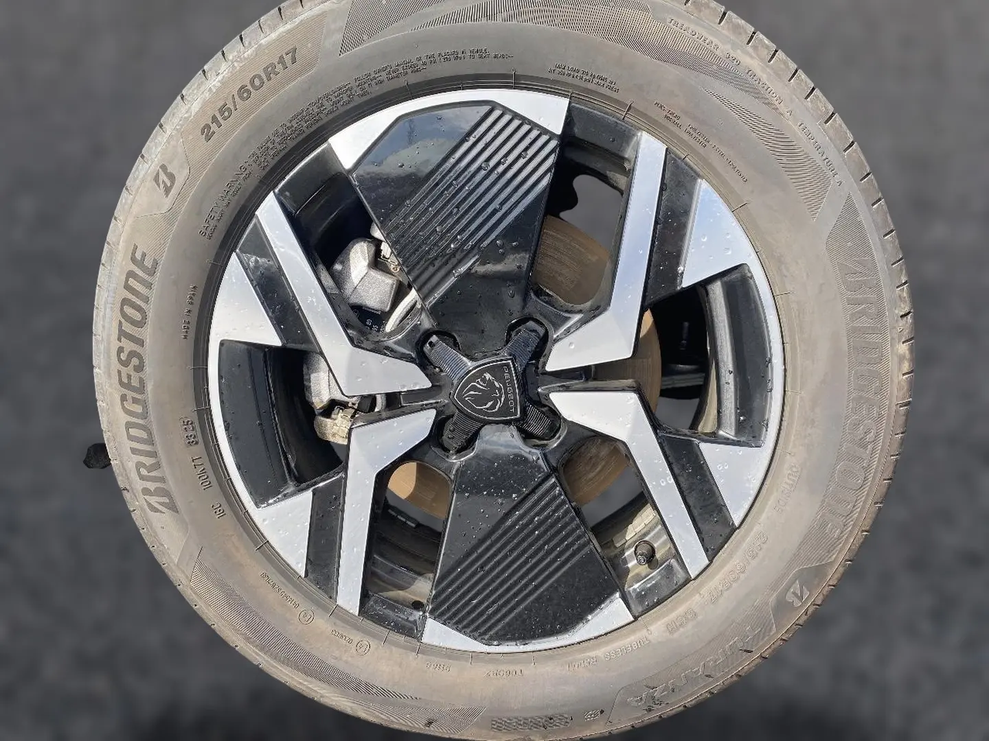 Gros plan sur la jante alu noire et argentée d’un Peugeot 2008 1.2 hybrid 145 GT e-DCS6 avec pneu Bridgestone.